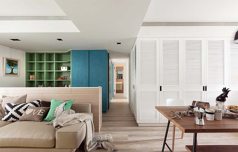 Giá sách màu xanh lá trở thành điểm nhấn nổi bật giữa các bức tường sơn trắng hiện đại, giúp căn phòng trở nên sinh động hơn