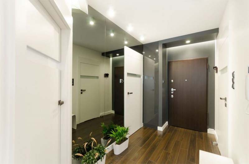 Lối vào căn hộ nhỏ sử dụng các gam màu trang nhã như nâu gỗ, xám và trắng